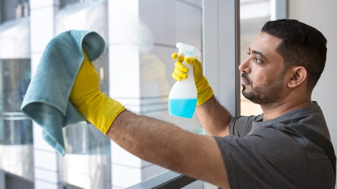 medium-shot-man-cleaning-office-window_23-2149345514